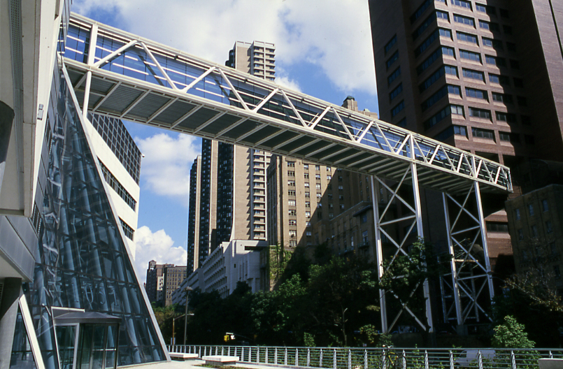 Photograph looking up towards glass sky bridge connecting two buildings