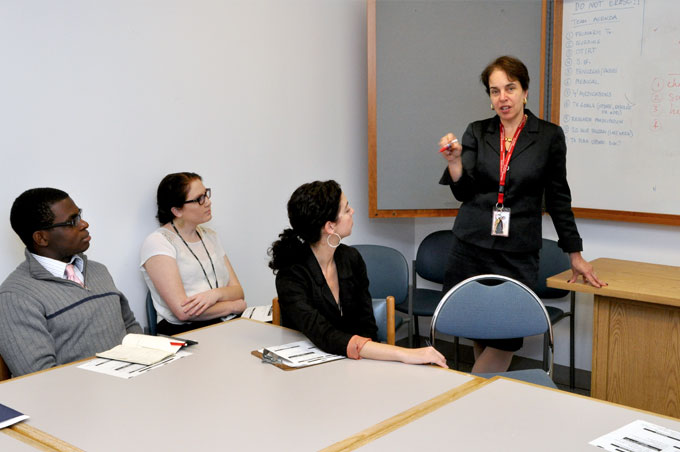 A woman presents to a group at a table.